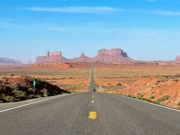 US road trips view of road with rocky cliffs in distance