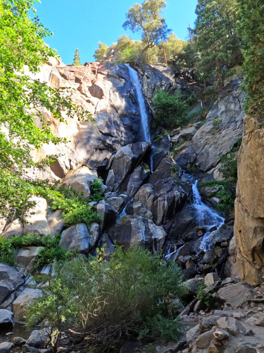 things to do in Kings Canyon National Park visit grizzly falls water falling down rocky cliff with trees