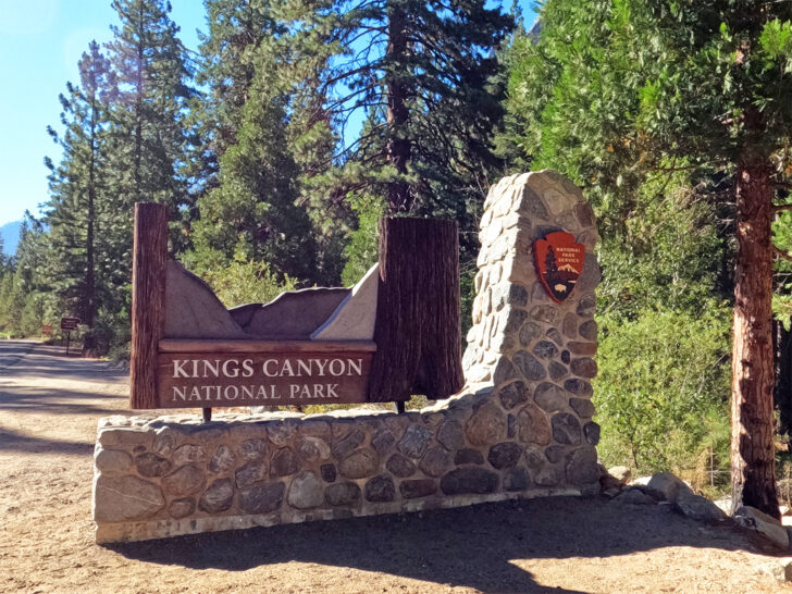 kings canyon national park california entrance sign with brick base and trees in background