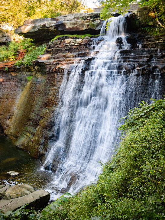 Cuyahoga Valley National Park in may lush waterfall cascading down stone wall with greenery