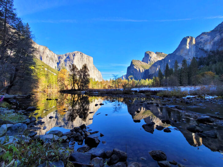 best national parks to visit in may Yosemite cliffs with lake and trees
