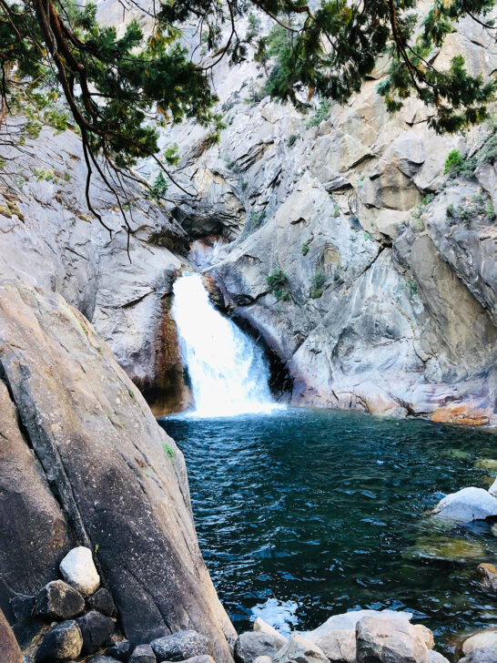 kings canyon and sequoia national park waterfall from rock to lake with tree above