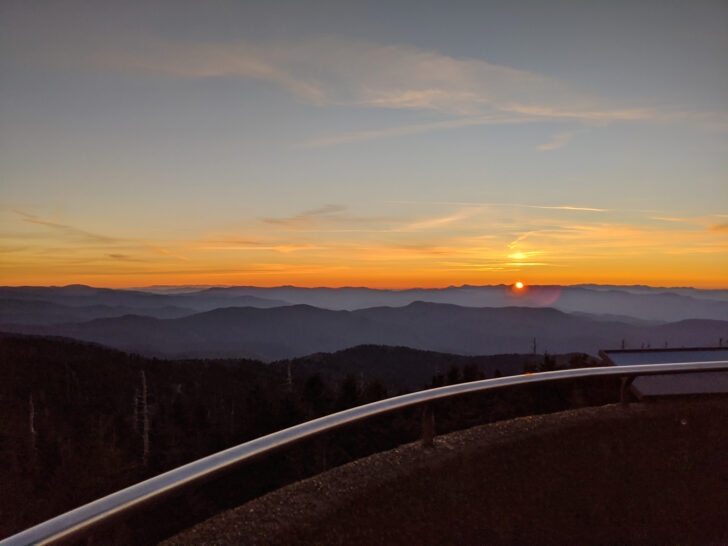 best national parks for kids sunset on smoky mountain scene with orange sky and railing in photo