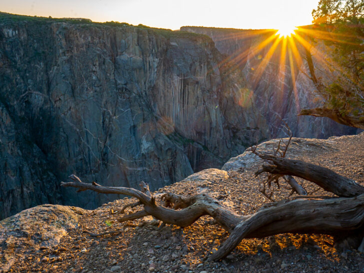 Colorado bucket list view of stick at edge of cliff at sunset
