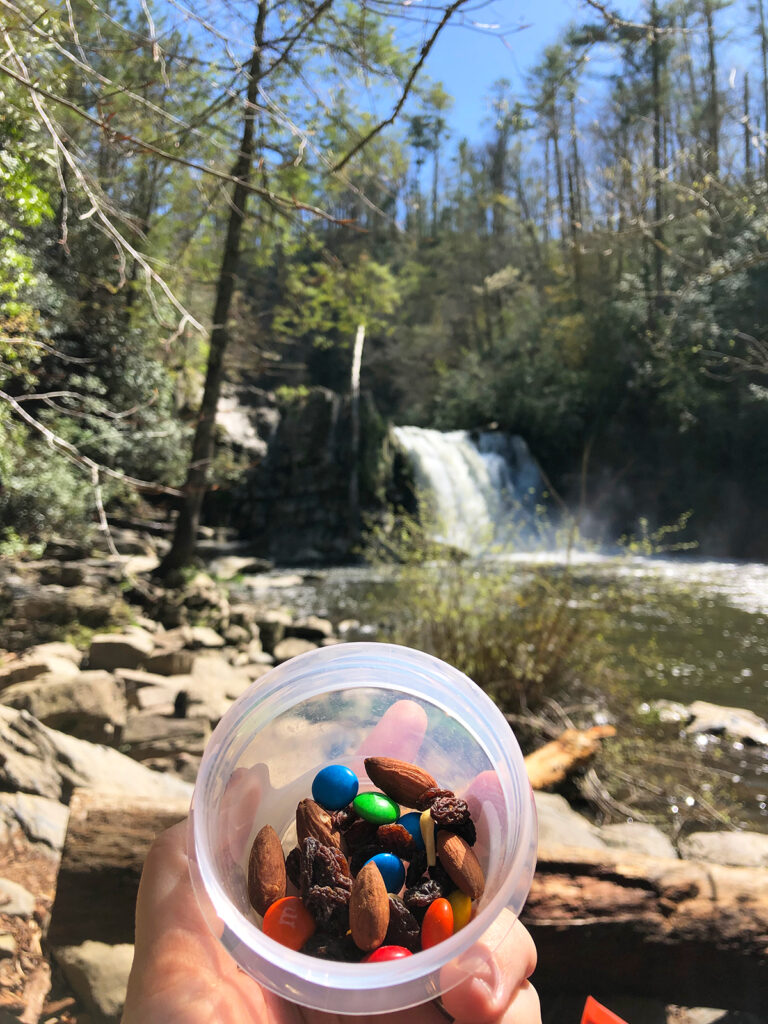 eating a snack during Abrams Falls hike view of nuts raisins and candy with waterfall scene in background