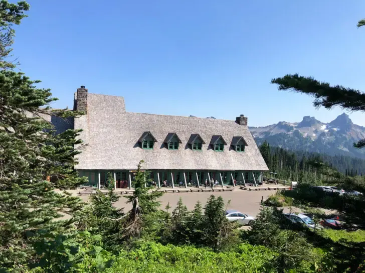 paradise lodge view of large cabin with parking lot in mountain scene