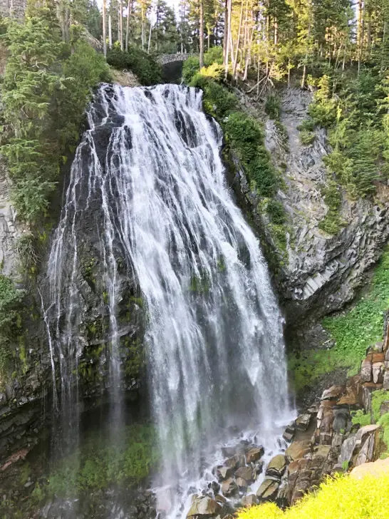 water gushing from cliff down to rocks below