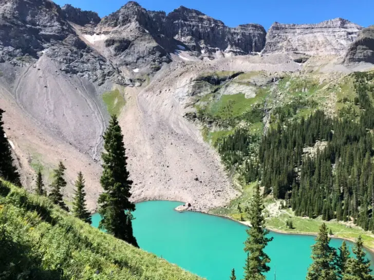 best colorado hikes view of teal lake with trees and Rocky Mountain ridges