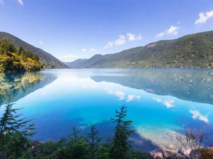 best places to visit in August view of blue lake with reflection of sky and mountains surrounding it