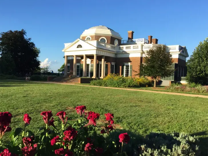 best places to visit in August view of large brick building with red roses in foreground of image