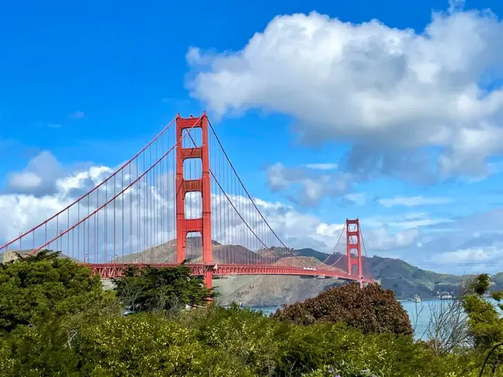 Golden Gate Bridge in San Francisco view of red bridge with hills in distance on sunny day