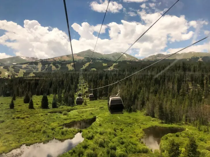 view of gondolas over mountain pasture where to travel in august