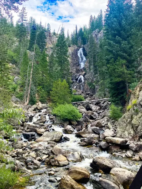Colorado hiking trails view of rocks and waterfall with trees surrounding it