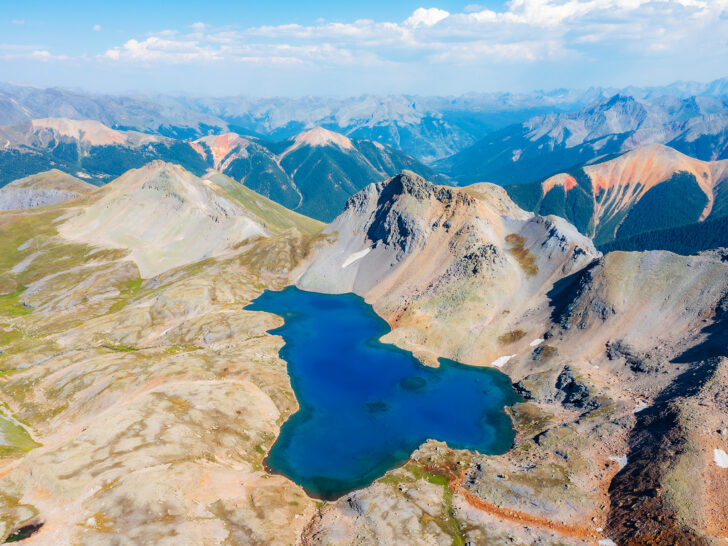 aerial view of jagged mountains blue lake in Colorado hiking trails