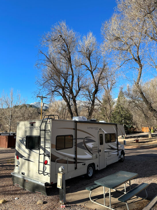 garden of the gods campground during winter with tan rv sitting near picnic table and trees in distance
