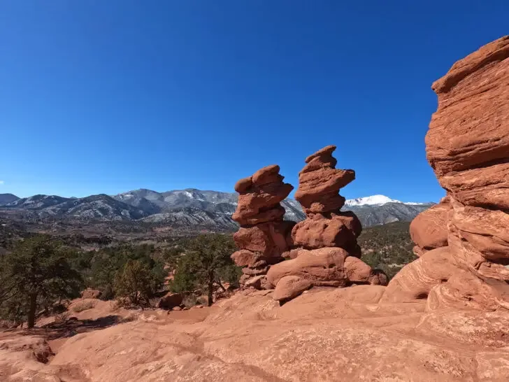 rocky formations with mountains in distance garden of the gods colorado