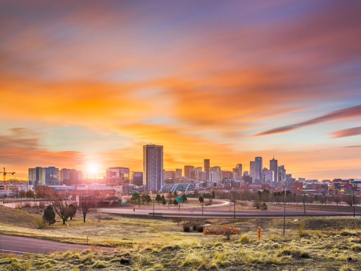 Denver skyline orange sky with tall buildings and grass on a Denver to Albuquerque drive