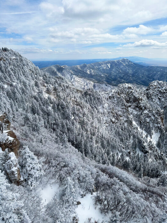 Denver to Albuquerque road trip views at Sandia Peak in Albuquerque with snowy mountain ridges and white clouds