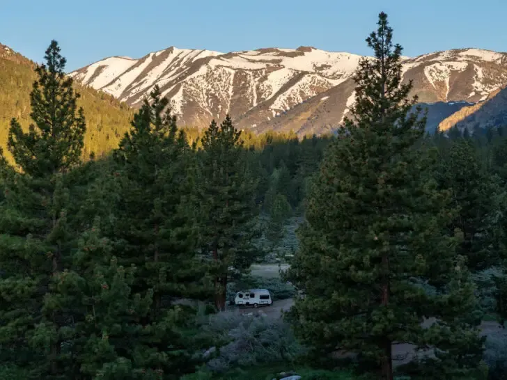 camper through the trees with mountains in distance