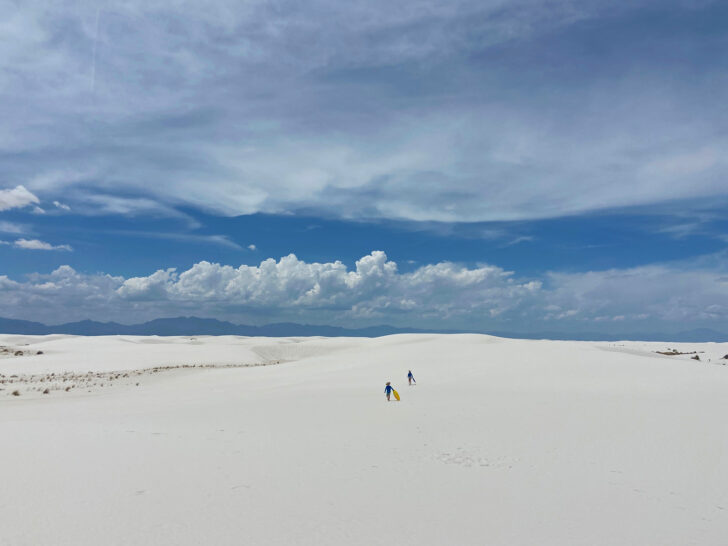 kids walking on white sand dunes with white clouds in sky during rv travel usa