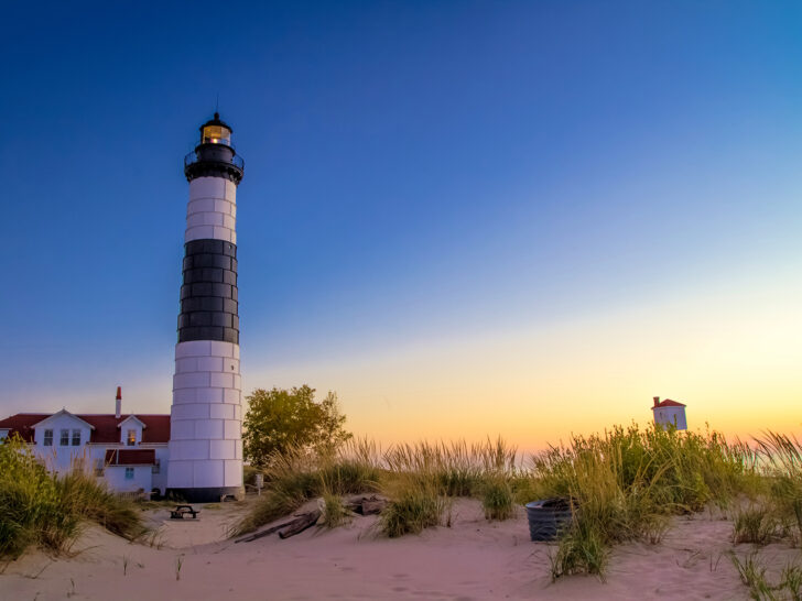 Ludington State Park lighthouse at dusk with white and black lighthouse sand dunes and tall grass