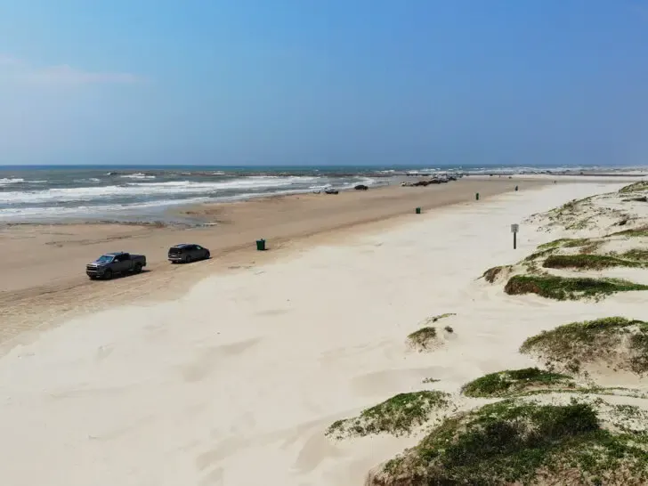 rv vacation ideas view of sandy beach with vehicles on it and sand dunes with ocean waves