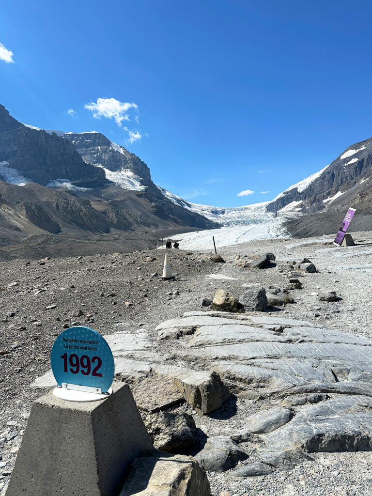 sign showing 1992 and rocky area with snowy glacier in the distance