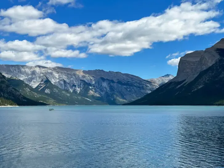 boat on lake with large mountains surrounding Banff things to do summer