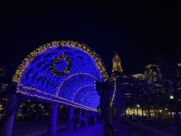 light up tunnel at night with Boston skyline in distance