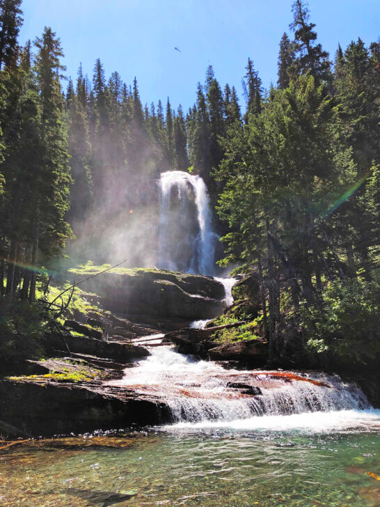 beautiful waterfall scene cascading down mountain with trees easy hikes glacier national park