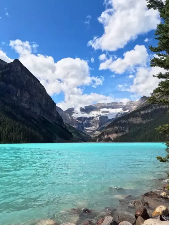 teal lakes with rocks at edge and mountains in distance