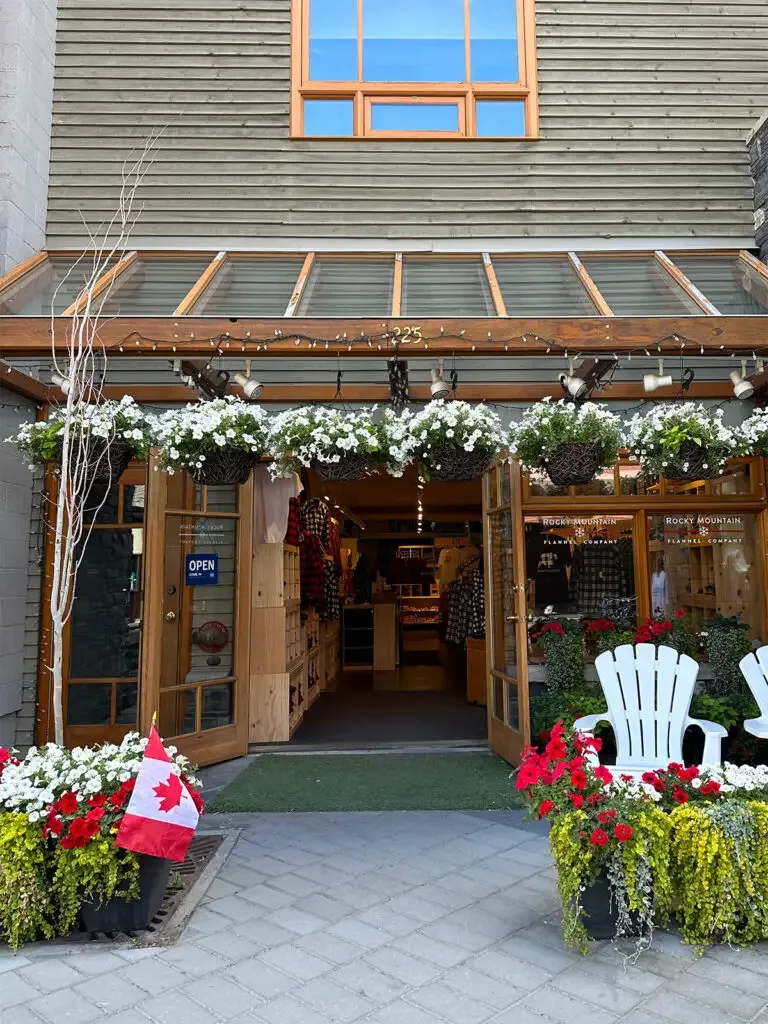 shop with flowers and chairs with sign that says open