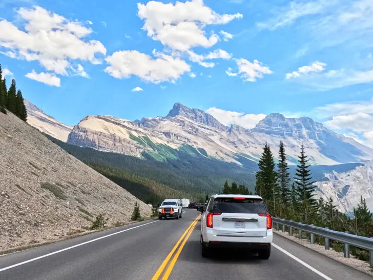 Banff National Park to jasper national park with cars on road and mountains in distance