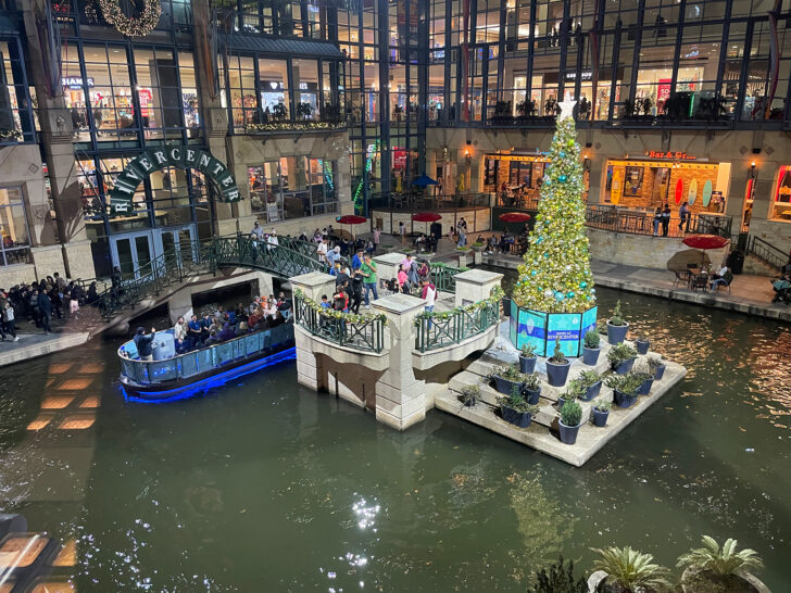 riverfront wit boat and large shopping center in December with Christmas tree