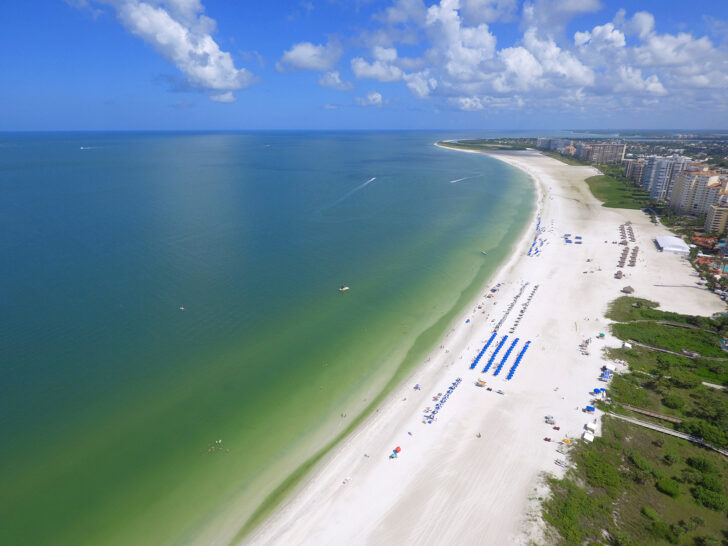 warm winter vacations in the US view of Florida beach from above with green water and city buildings