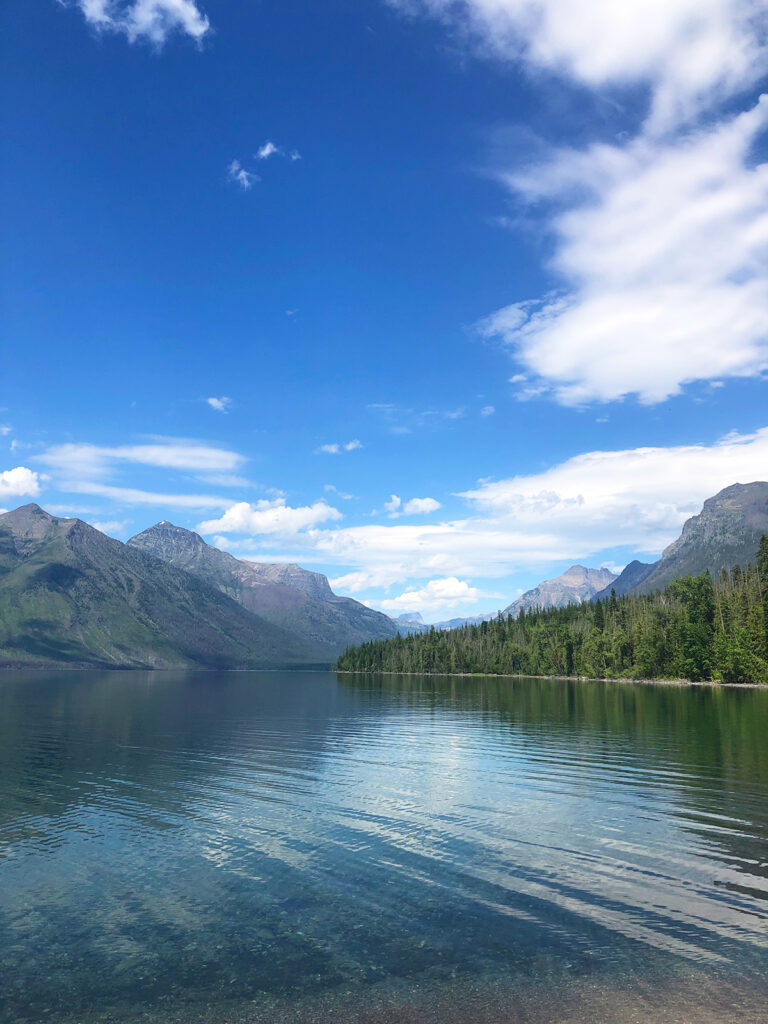glacier national park must do view of smooth water lake with mountains in distance