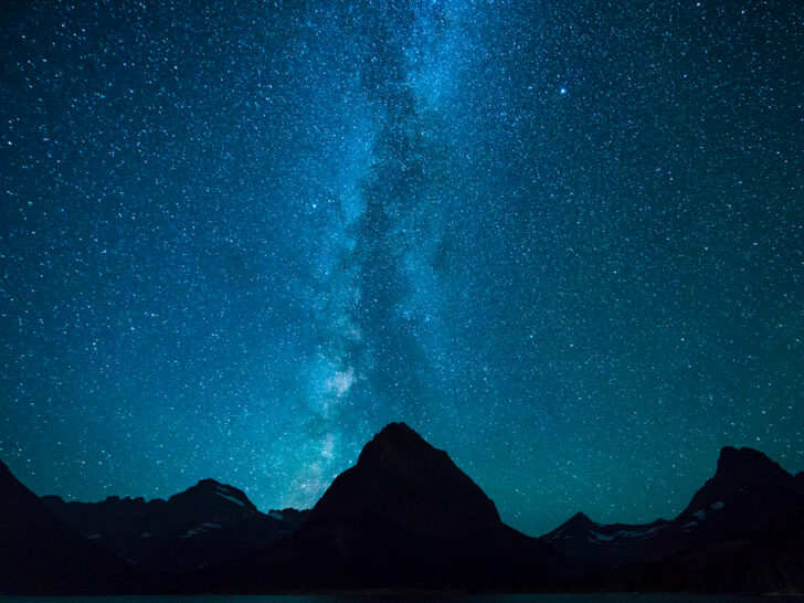 Milky Way at night above mountain peaks in Many Glacier