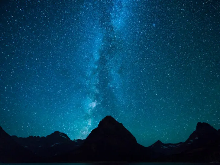 Milky Way at night above mountain peaks in Many Glacier