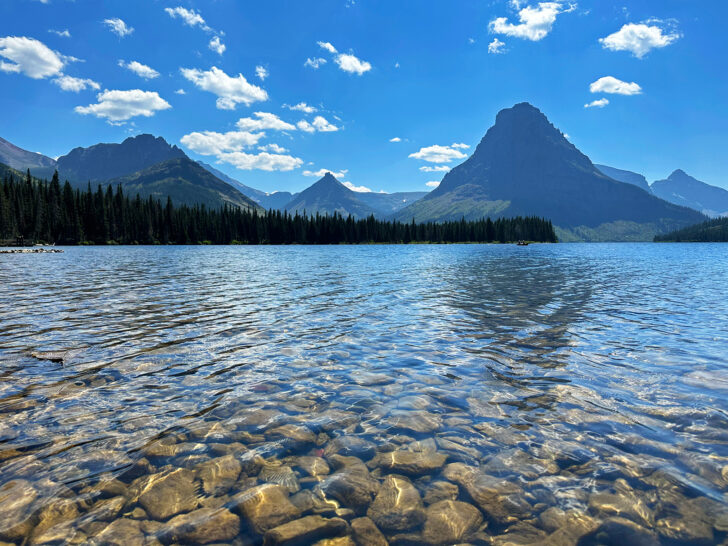 best things to do in glacier national park view of lake with rocks and mountains in distance
