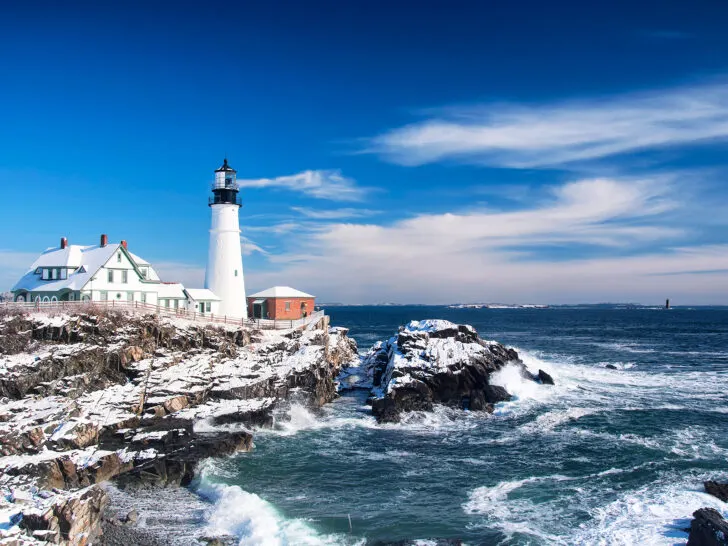 winter road trips view of lighthouse along coast with dusting of snow