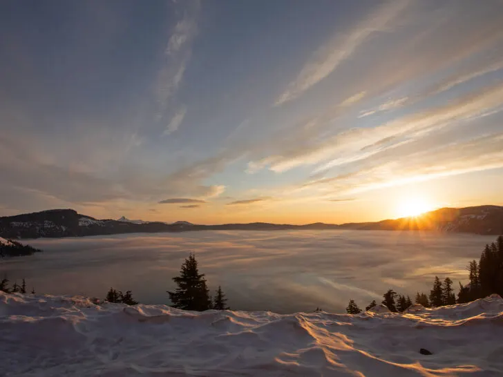 sunrise over lake with snow and clouds