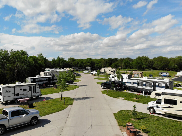 view of campers lined up at a campground on a sunny day