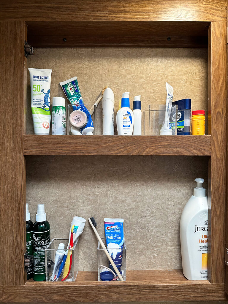 inside view of motorhome vanity with bathroom essentials like lotion, toothpaste, etc camping RV checklist