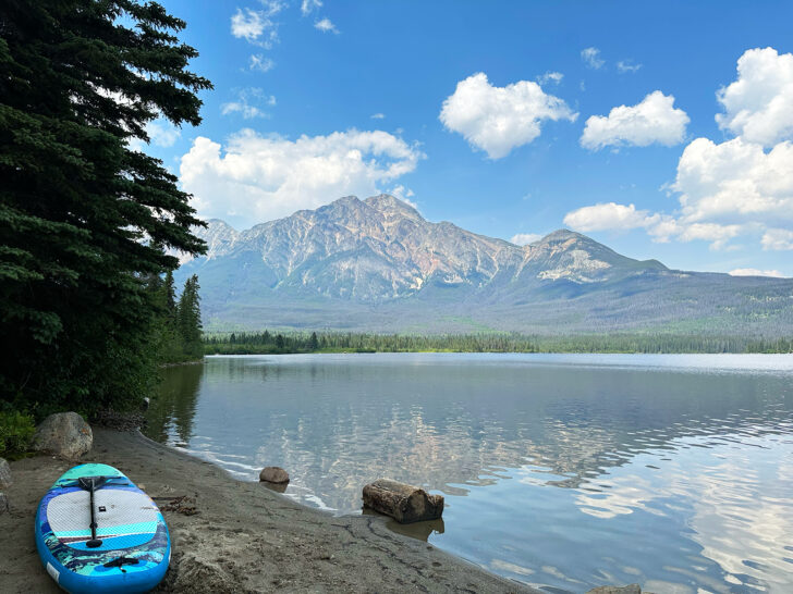 paddle board sitting on edge of lake with mountain in distance Jasper National Park