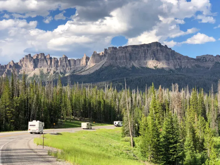 tips and tricks for beginning rving view of three campers driving on road with mountain in distance